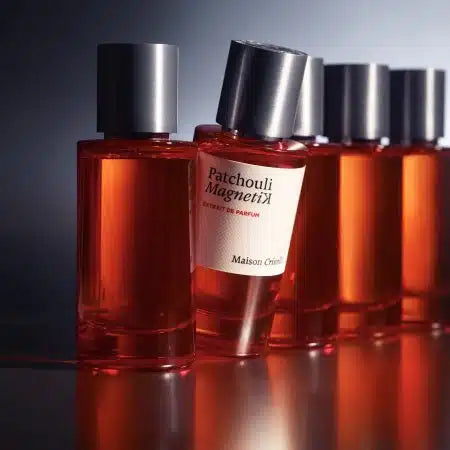 Maison Crivelli Patchouli Magnetik extrait bottles arranged in a stylish display with a warm glow