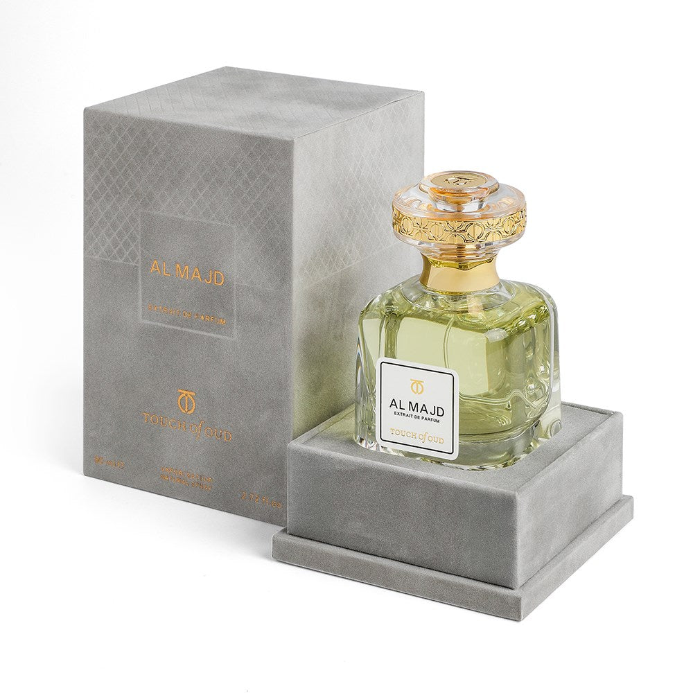 Touch of Oud Al Majd extrait perfume with elegant gold-capped glass bottle and gray velvet box
