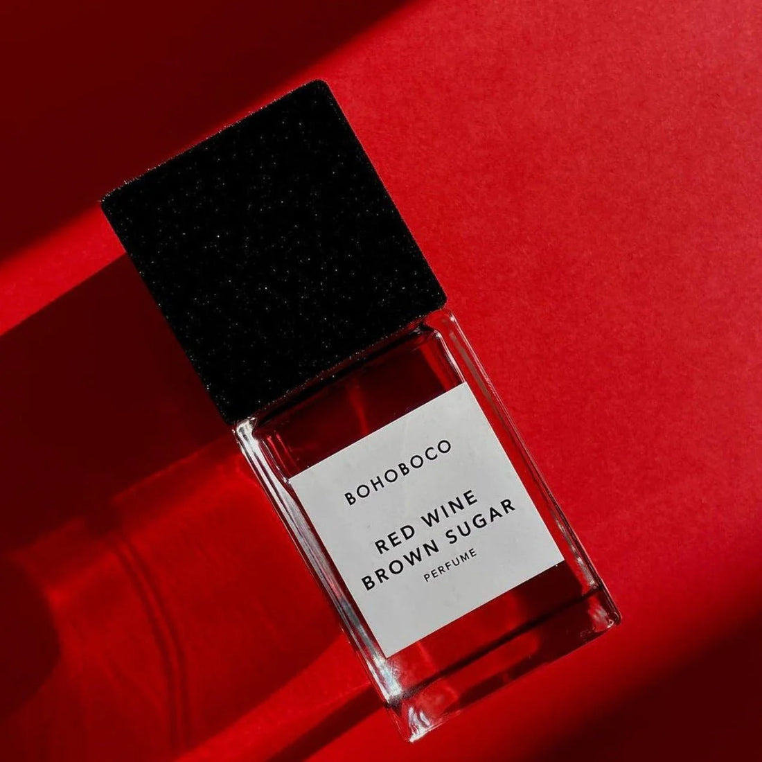 BOHOBOCO perfume bottle labeled RED WINE • BROWN SUGAR 50 ml on vibrant red background