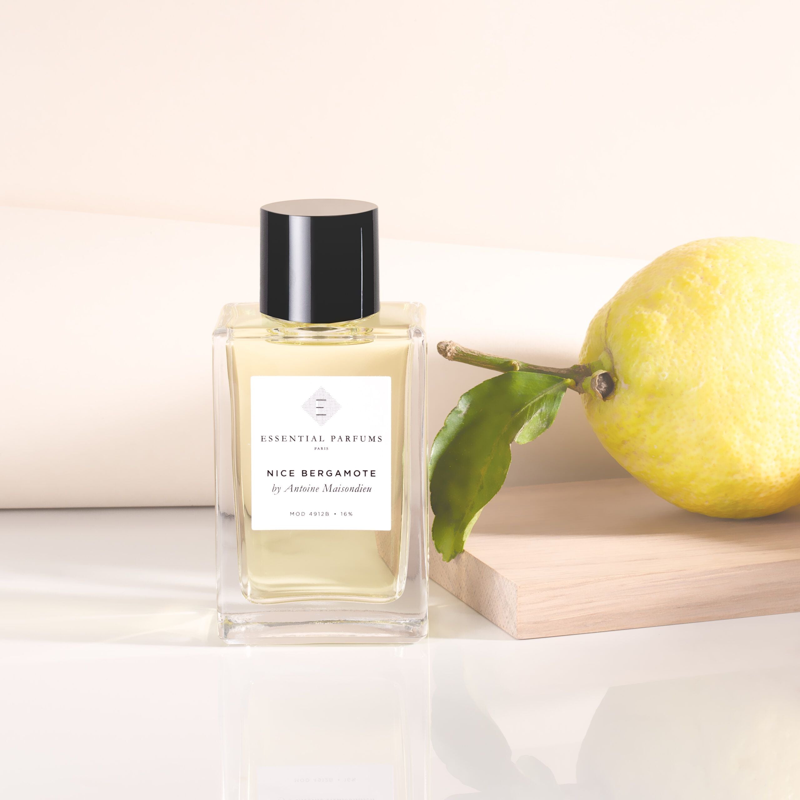Essential Parfums Nice Bergamote perfume bottle with lemon fruit on wooden block