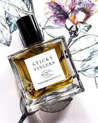 Francesca Bianchi Sticky Fingers perfume in a clear bottle with elegant floral background