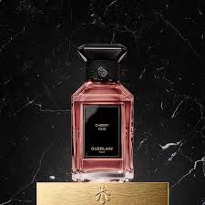 Guerlain Cherry Oud perfume in a stylish bottle with a pink hue on a dark marble background