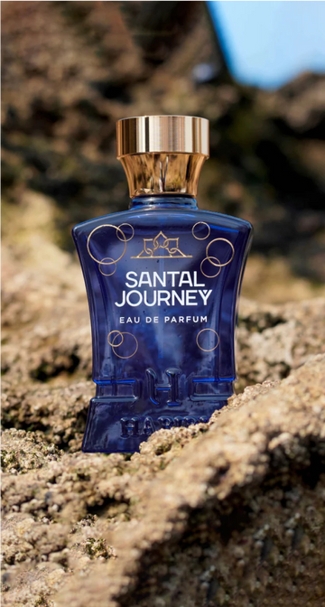 Santal Journey perfume by HABIBI NEW YORK in a blue bottle with gold cap placed on textured rock surface