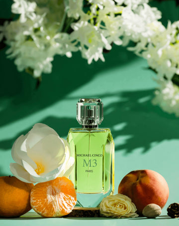 M3 fragrance by Michael Cinco perfume bottle surrounded by white flower and fresh citrus fruits