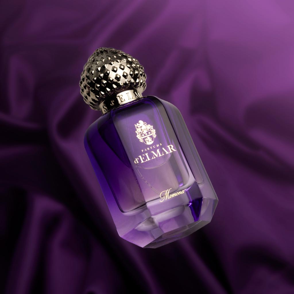 DELMAR MOMONA perfume Dubai bottle with ornate gold cap and purple glass against dark background