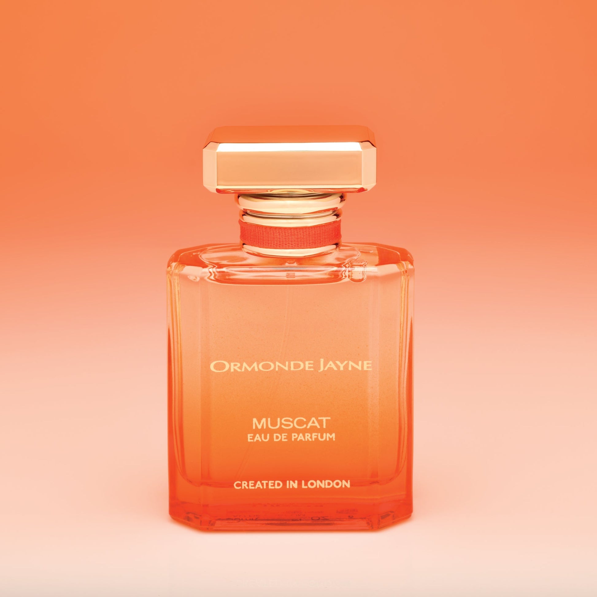 Ormonde Jayne Muscat niche perfume bottle with orange gradient background and gold cap