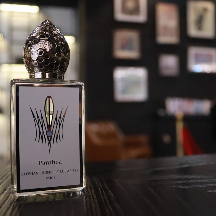 Stephane Humbert Lucas Panthea niche perfume bottle with detailed hexagonal cap on dark wooden surface
