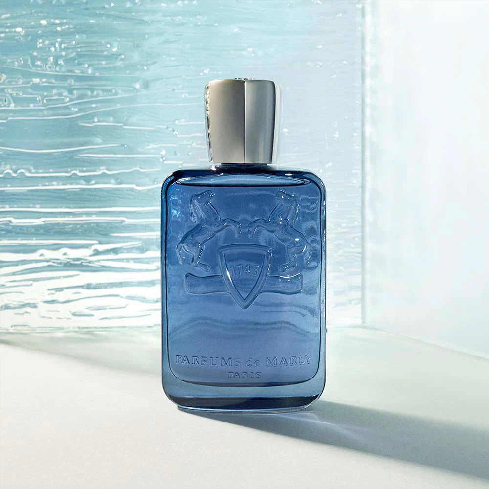 Parfums De Marly Sedley for men blue glass perfume bottle with silver cap on textured glass background