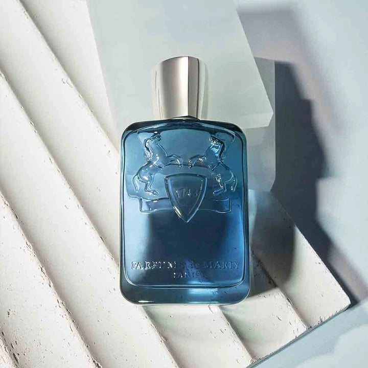Parfums De Marly Sedley for men blue glass perfume bottle with silver cap on white and gray background