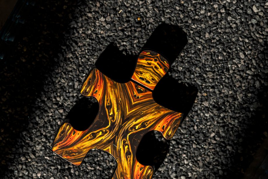 Puzzle Lal fragrance perfume bottle shaped like a fiery orange puzzle piece against a dark background