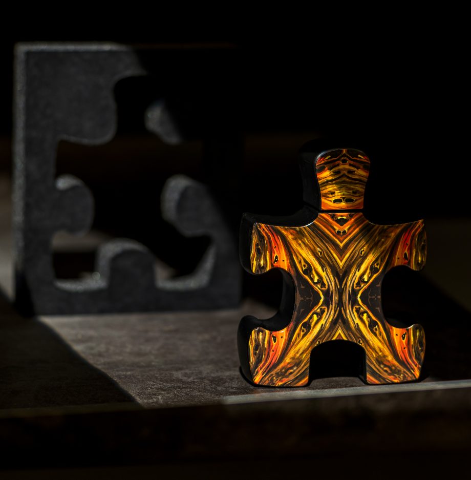 Puzzle Lal fragrance by Puzzle Perfume shaped like a decorative amber puzzle piece