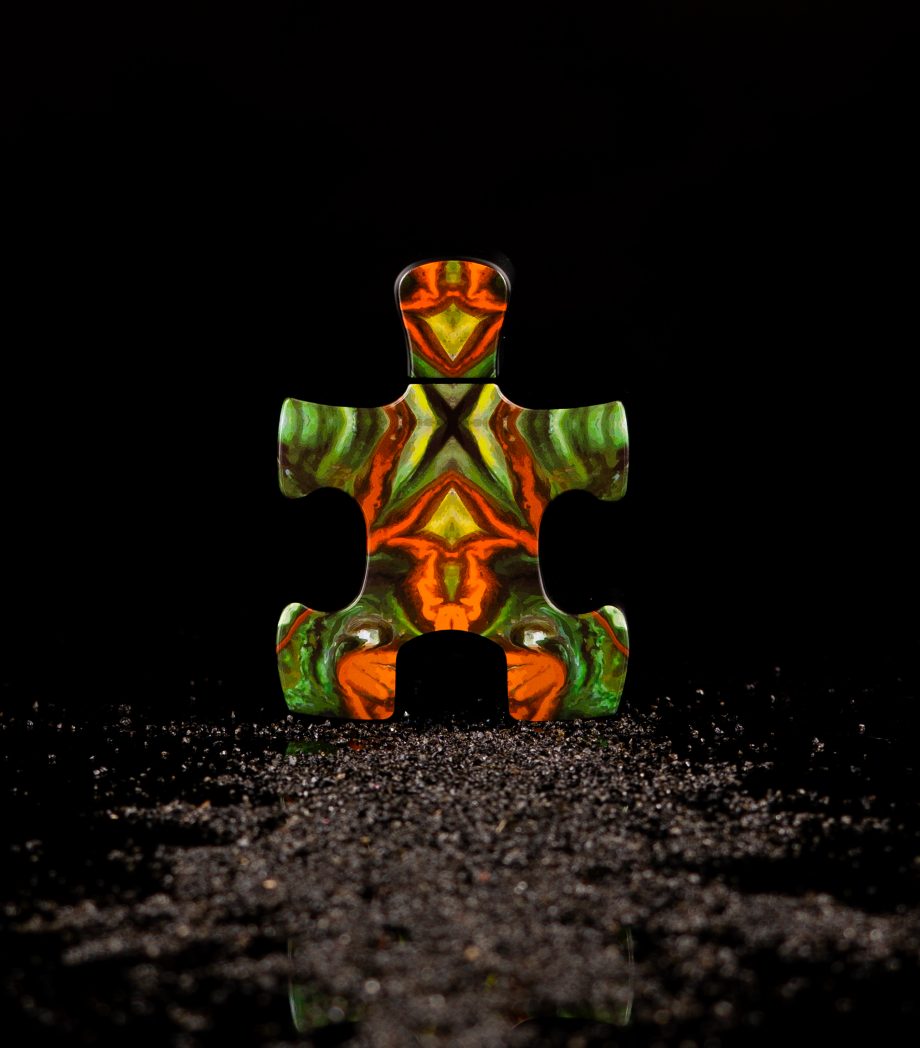 Colorful puzzle piece with vibrant orange green pattern representing Puzzle Purgatory perfume by Puzzle Perfume