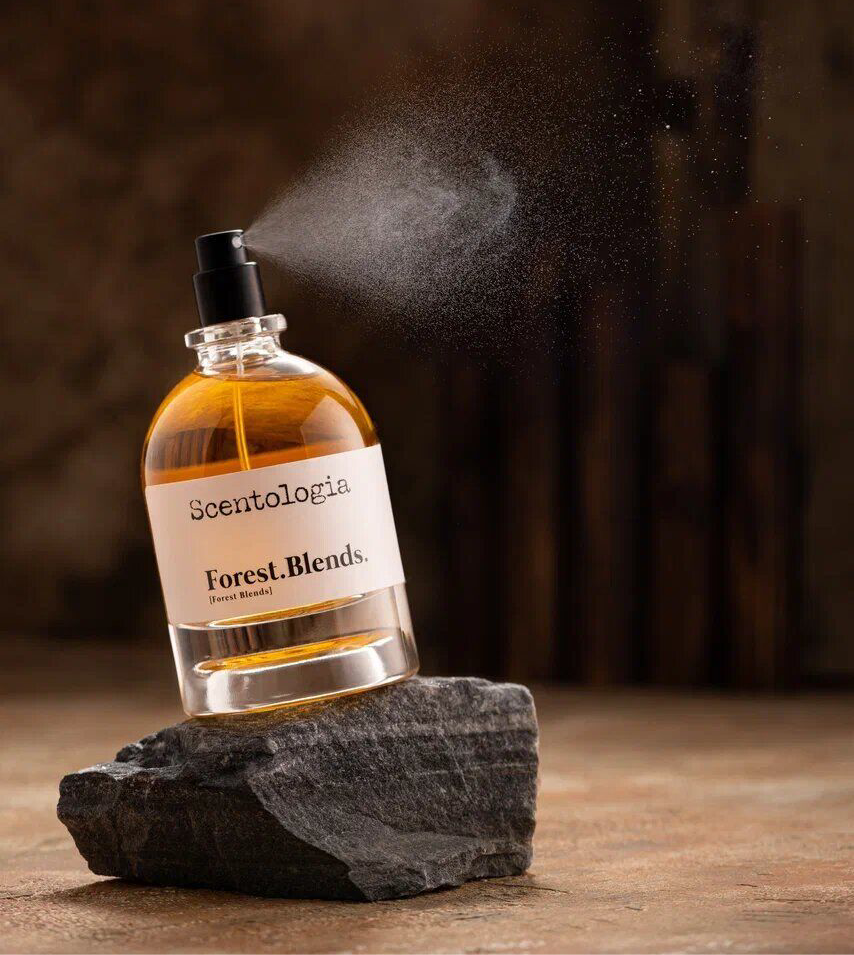 Scentologia perfume bottle labeled Forest. Blends. by Scentologia spraying on dark textured stone