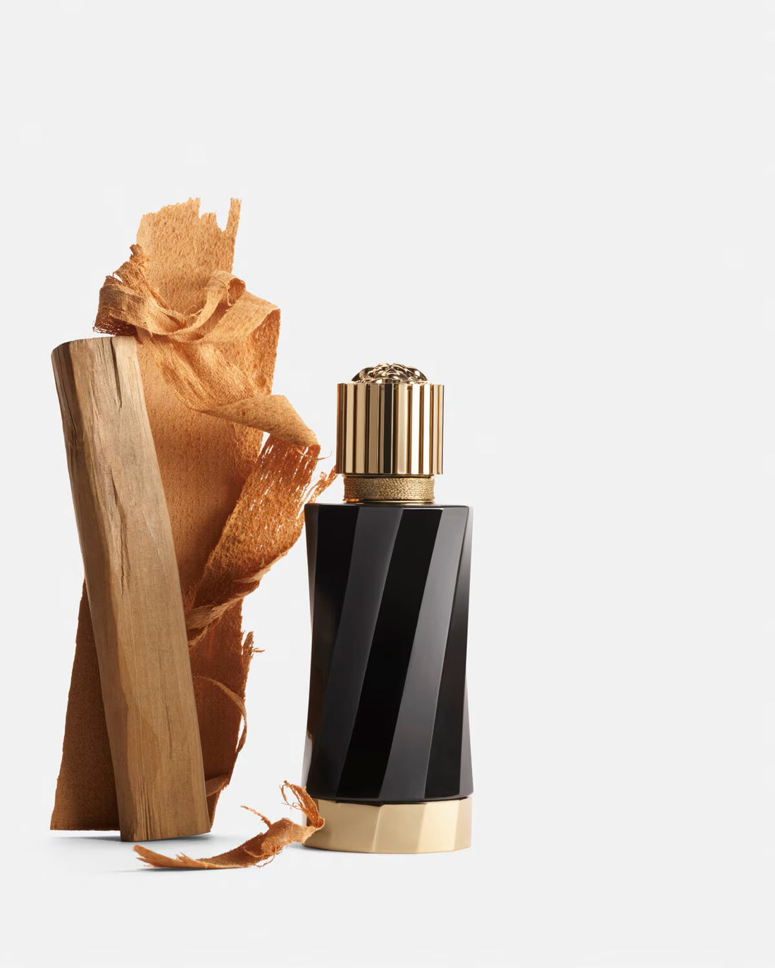 Versace Santal Boise Eau de Parfum black and gold bottle with sandalwood pieces on white background