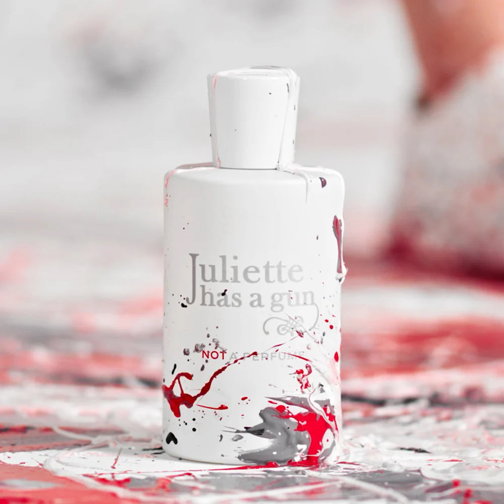 Juliette Has a Gun Not a Perfume 100ml bottle with artistic splashes on a white background