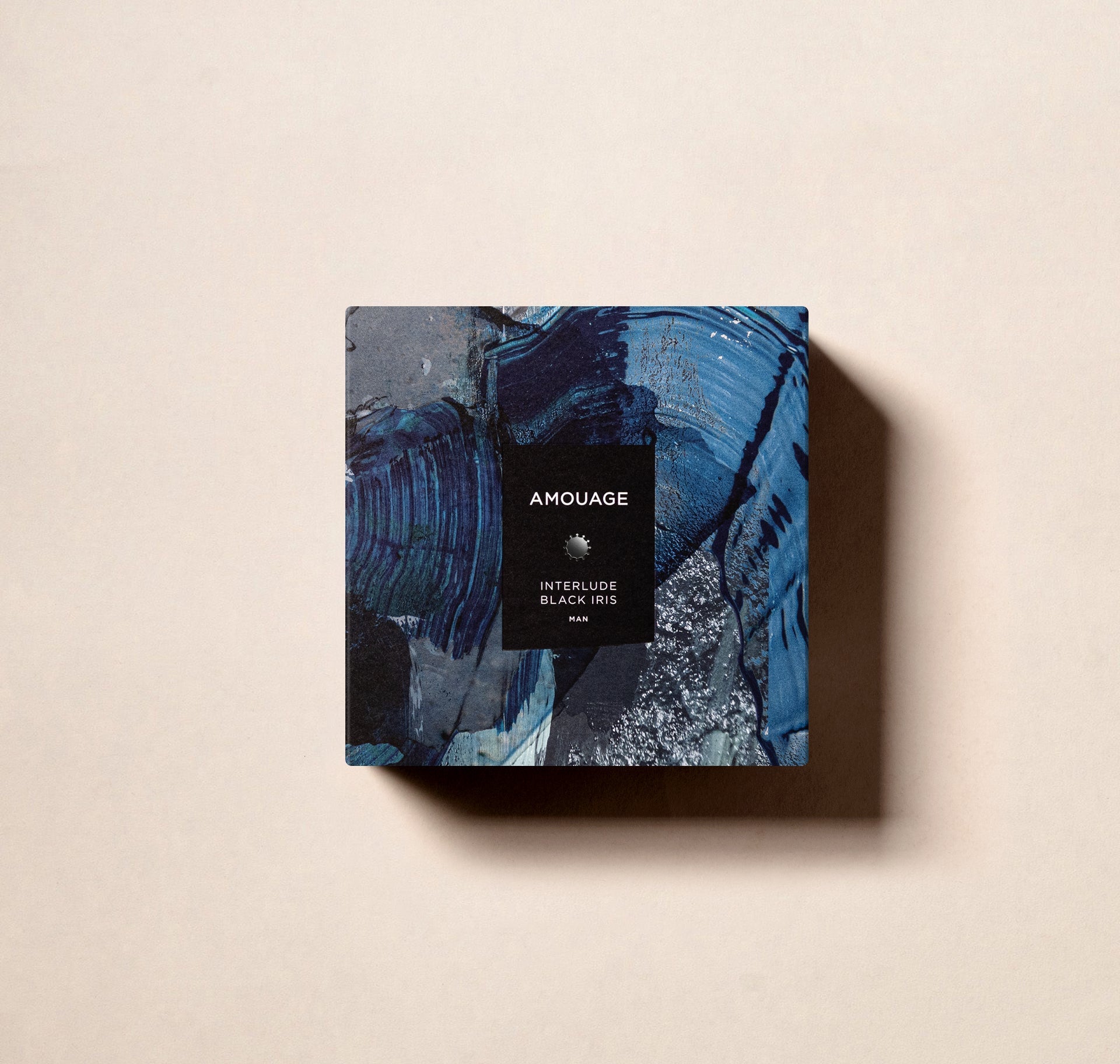 Amouage Interlude Black Iris Man perfume box with artistic blue and black design on beige background