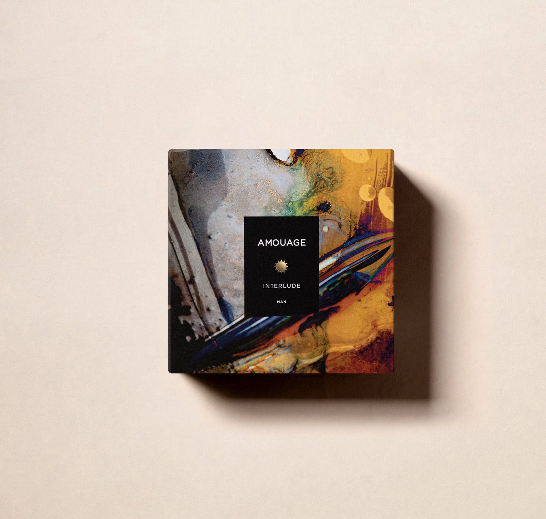 Amouage Interlude Man perfume in a deep blue bottle with a gold cap and emblem