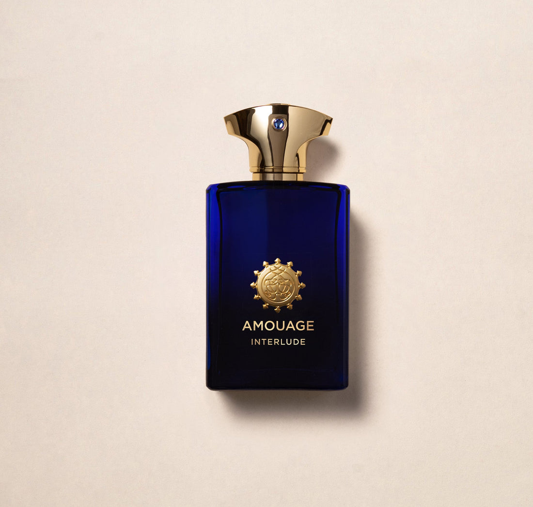 Amouage Interlude Man perfume in a deep blue bottle with a gold cap and emblem
