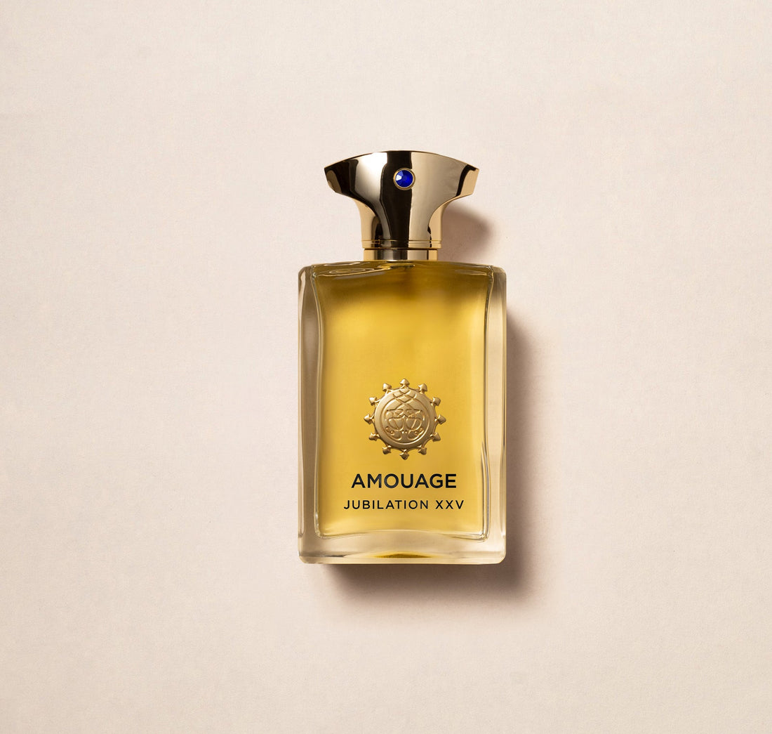 Amouage Jubilation XXV Man perfume bottle with gold cap and amber liquid on beige background