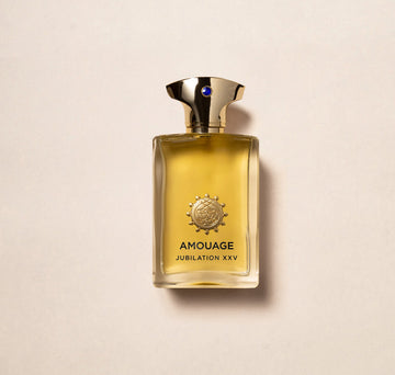Amouage Jubilation XXV Man perfume bottle with gold cap and amber liquid on beige background