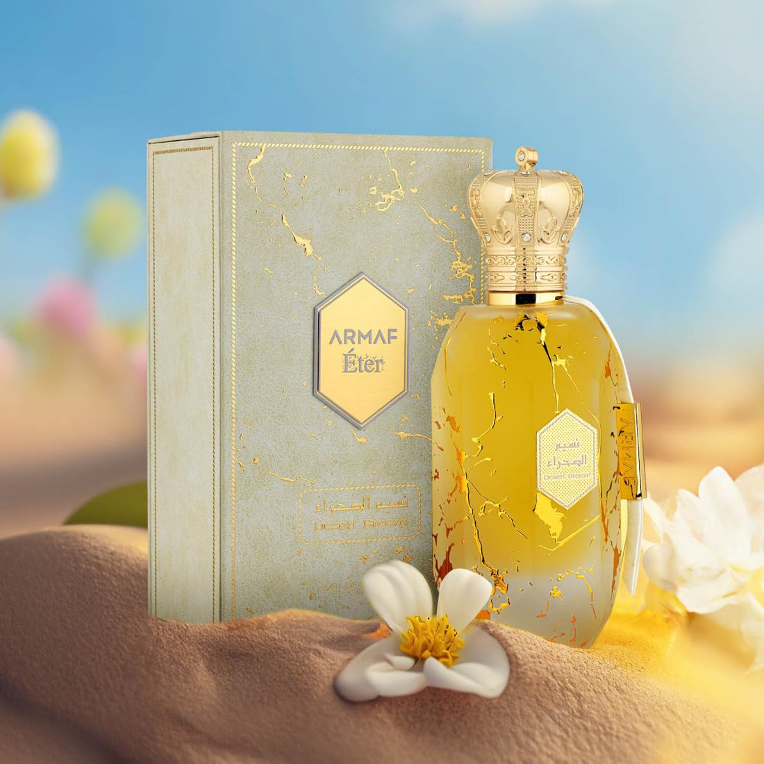 ARMAF Desert Breeze perfume bottle with gold crown cap and decorative box on sand with white flowers