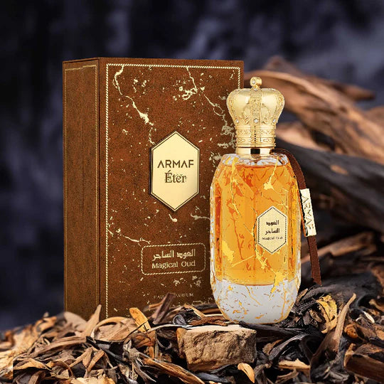 ARMAF ÉTER MAGICAL OUD perfume bottle with gold crown cap and matching brown box on natural wood background