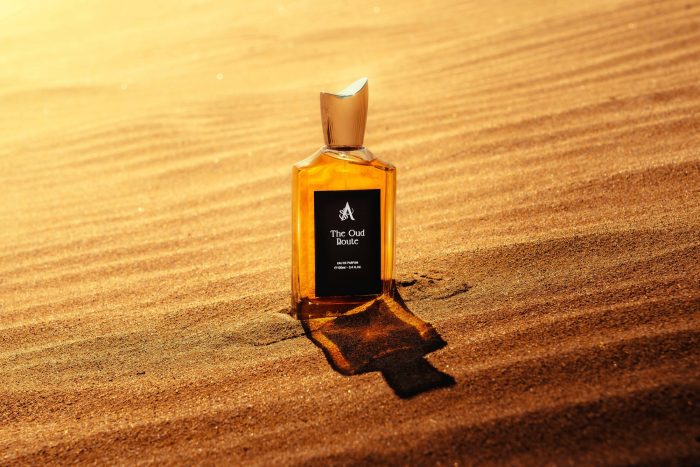 Artal Perfumes bottle of Oud perfume Dubai placed on golden sand with sunlight reflection