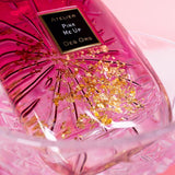 Close-up of Atelier Des Ors Pink Me Up perfume bottle with gold flakes in pink liquid