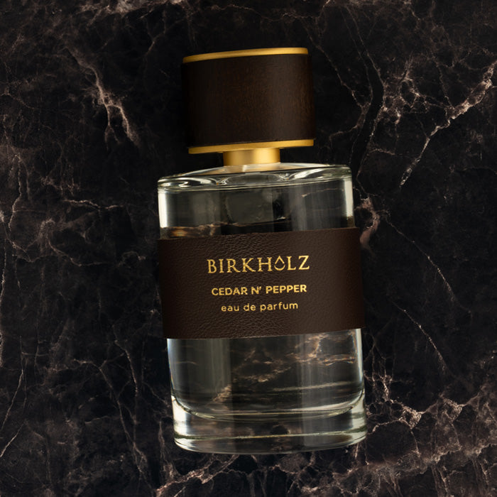 Birkholz Cedar N' Pepper 100 ML perfume bottle with brown leather label and gold accents on dark marble surface