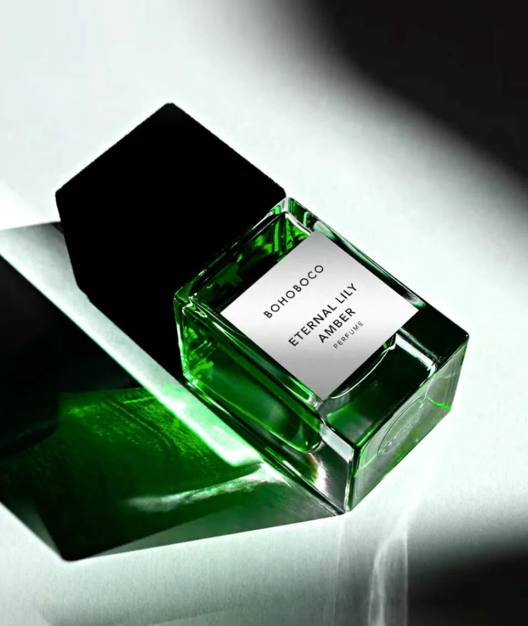 BOHOBOCO ETERNAL LILY AMBER perfume bottle with black cap on greenish background