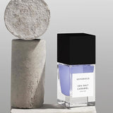 BOHOBOCO sea salt caramel perfume bottle with black cap next to textured stone decor