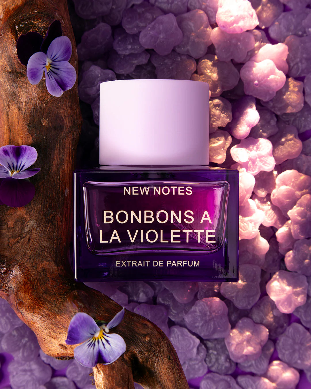 NEW NOTES Bonbons A La Violette perfume bottle with purple fragrance and white cap on purple background
