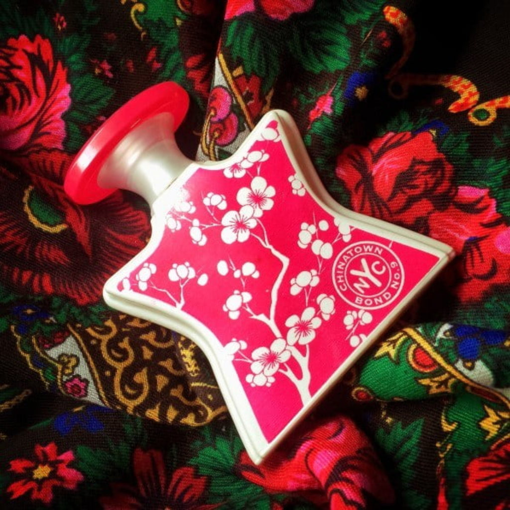 Bond No 9 Chinatown 100ml perfume bottle with floral design on colorful fabric background