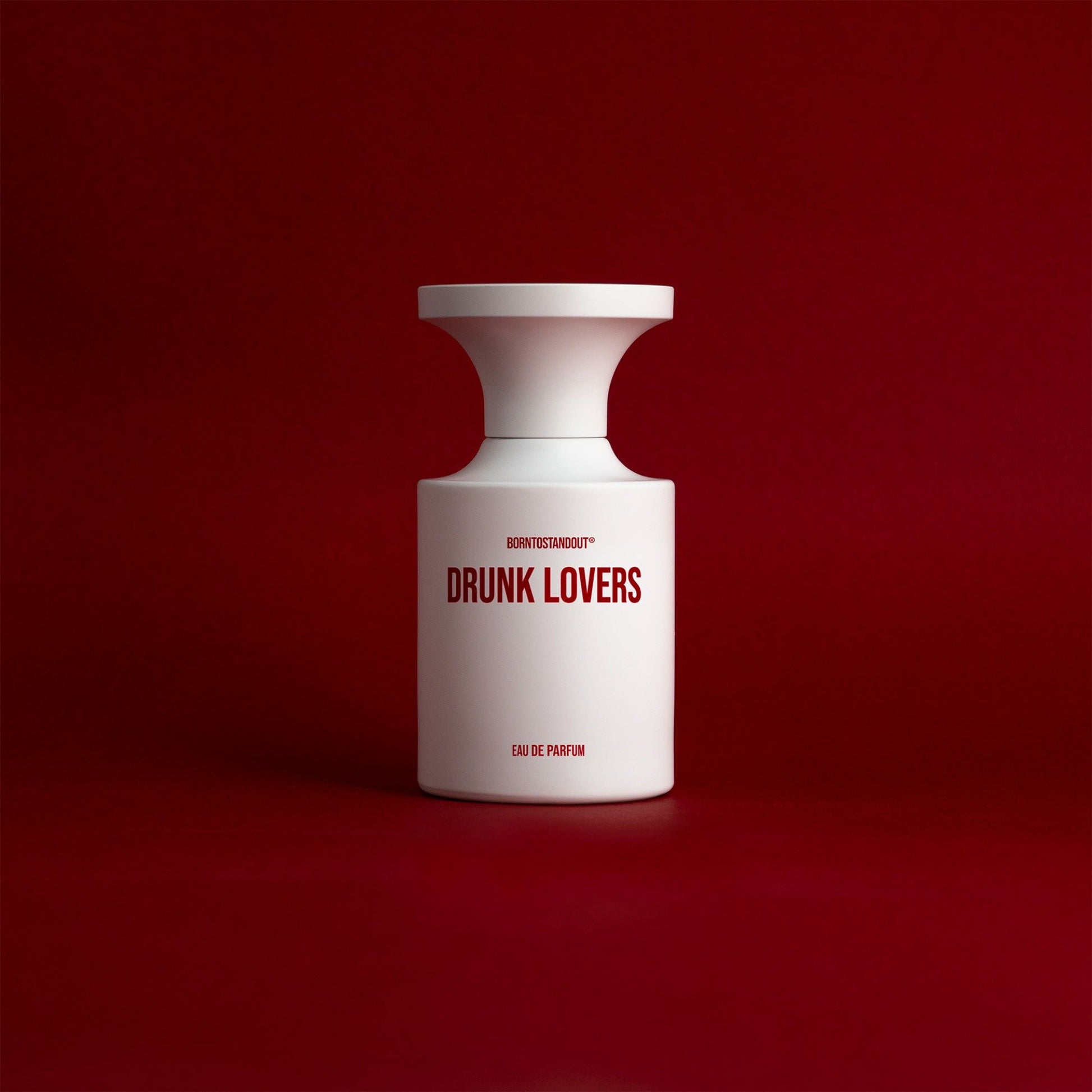 White BORNTOSTANDOUT Drunk Lovers niche perfume bottle on red background