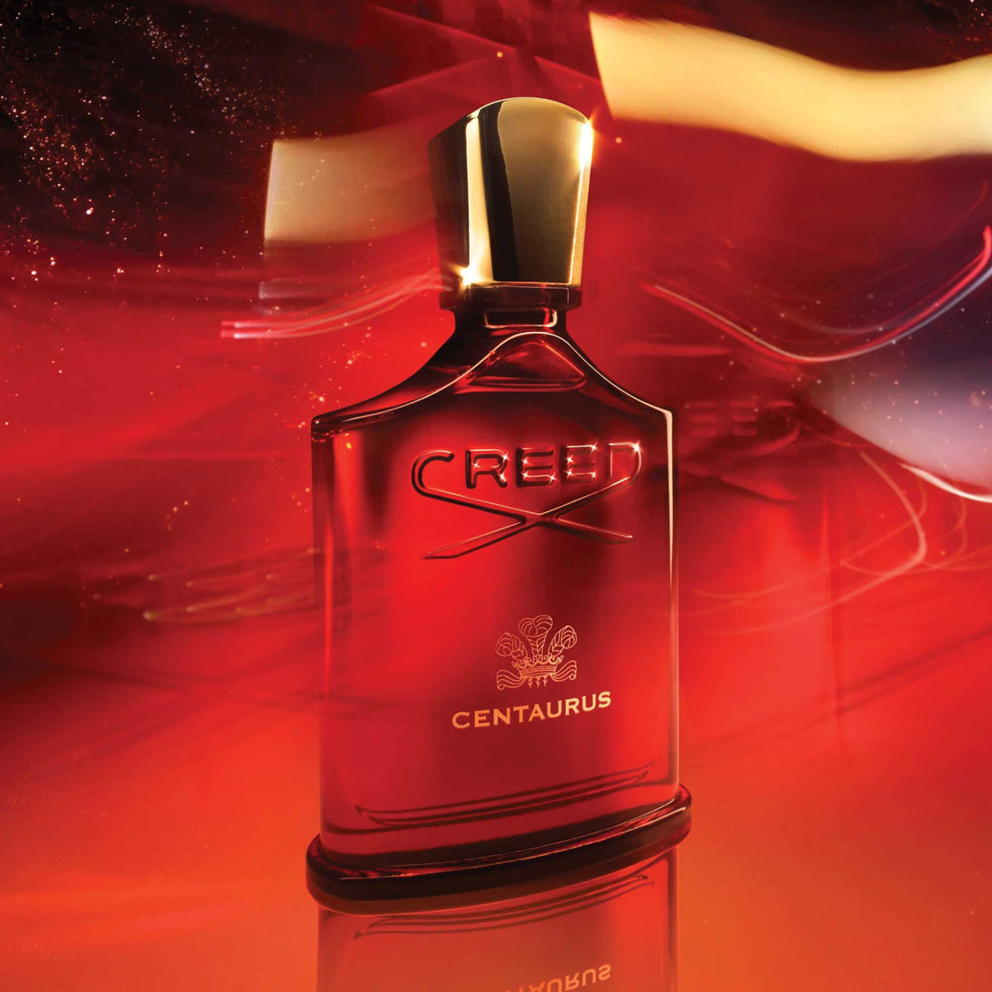Creed Millesime Centaurus 100ml perfume bottle with gold cap and red reflective background