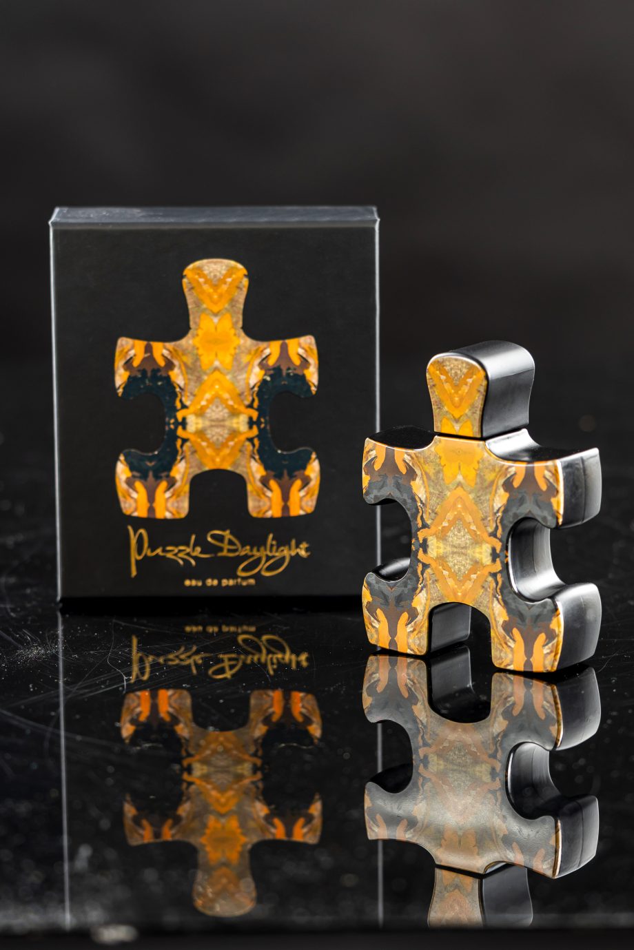 Puzzle Perfume Daylight perfume 90ML with vibrant orange puzzle piece design on black background