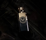 Electimuss Vici Leather perfume bottle with gold and black design placed on black leather jacket
