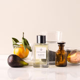 Essential Parfums Fig Infusion perfume bottle with fresh fig fruit and citrus on white surface