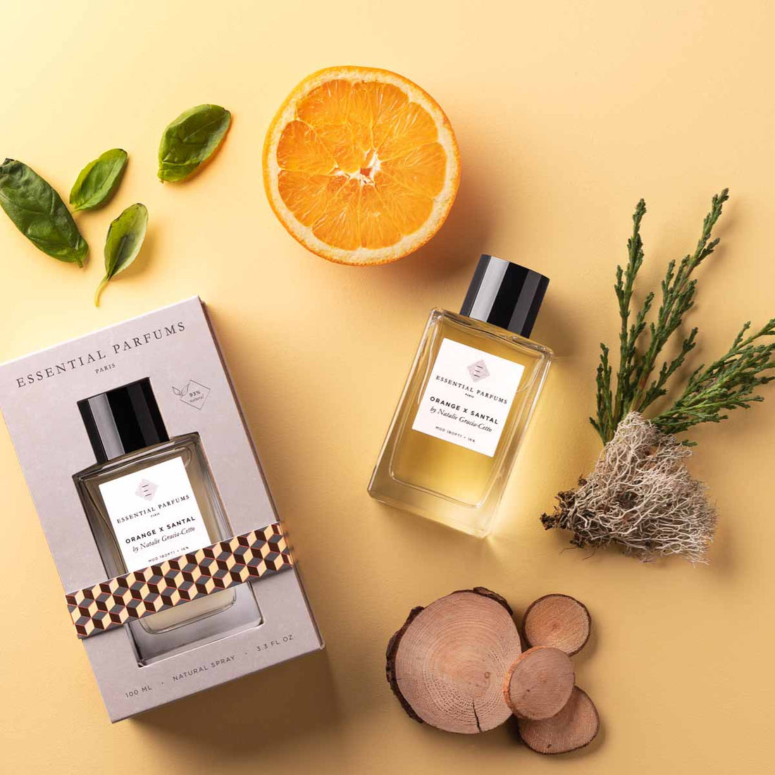 Essential Parfums Orange X Santal 100ml perfume bottle with box, orange slice, and natural ingredients
