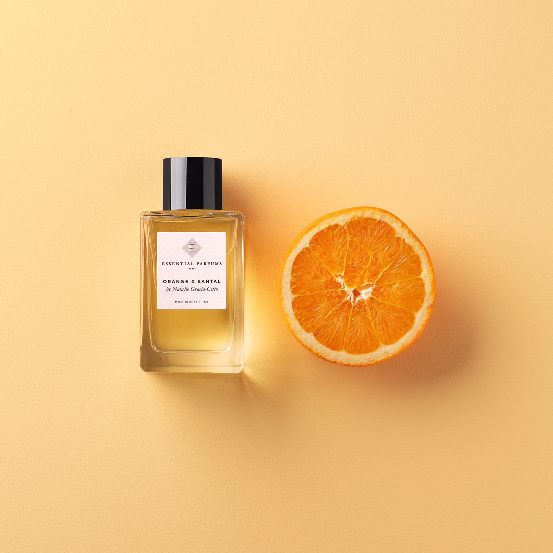 Essential Parfums Orange X Santal 100ml perfume bottle with box, orange slice, and natural ingredients