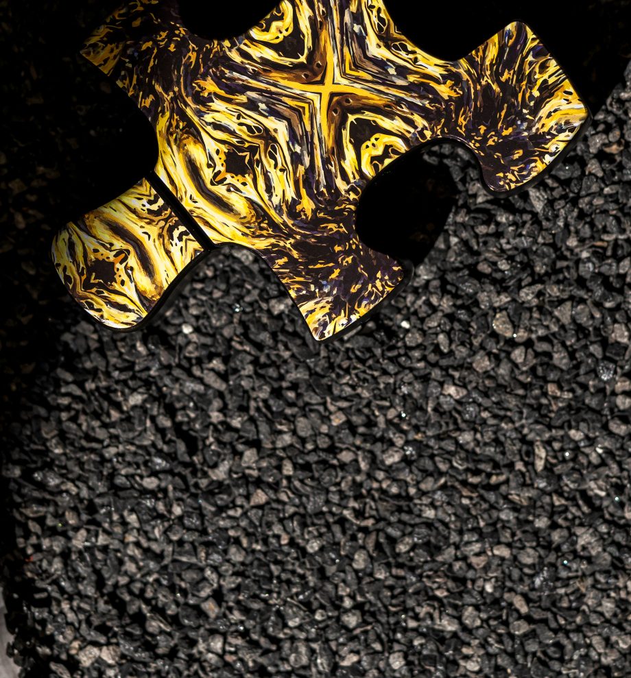 Puzzle perfume bottle cap with gold black pattern on gravel surface for Fibonacci perfume Dubai