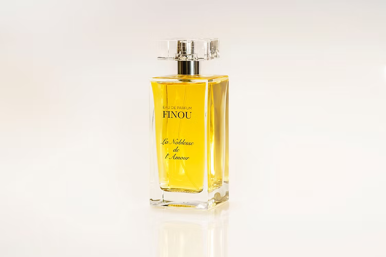 Finou La Noblesse Amour perfume in clear rectangular glass bottle with golden liquid and faceted cap