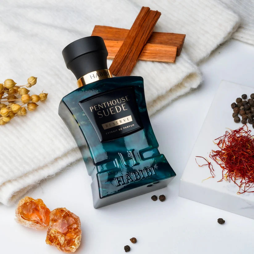 HABIBI NEW YORK Penthouse Suede fragrance bottle with spices and wooden sticks on white fabric