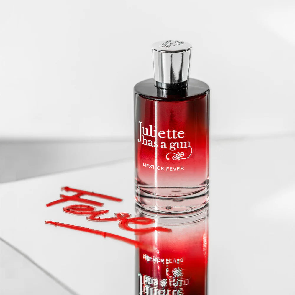 Juliette Has a Gun Lipstick Fever Perfume Bottle with a Reflective Surface and Bold Red Script