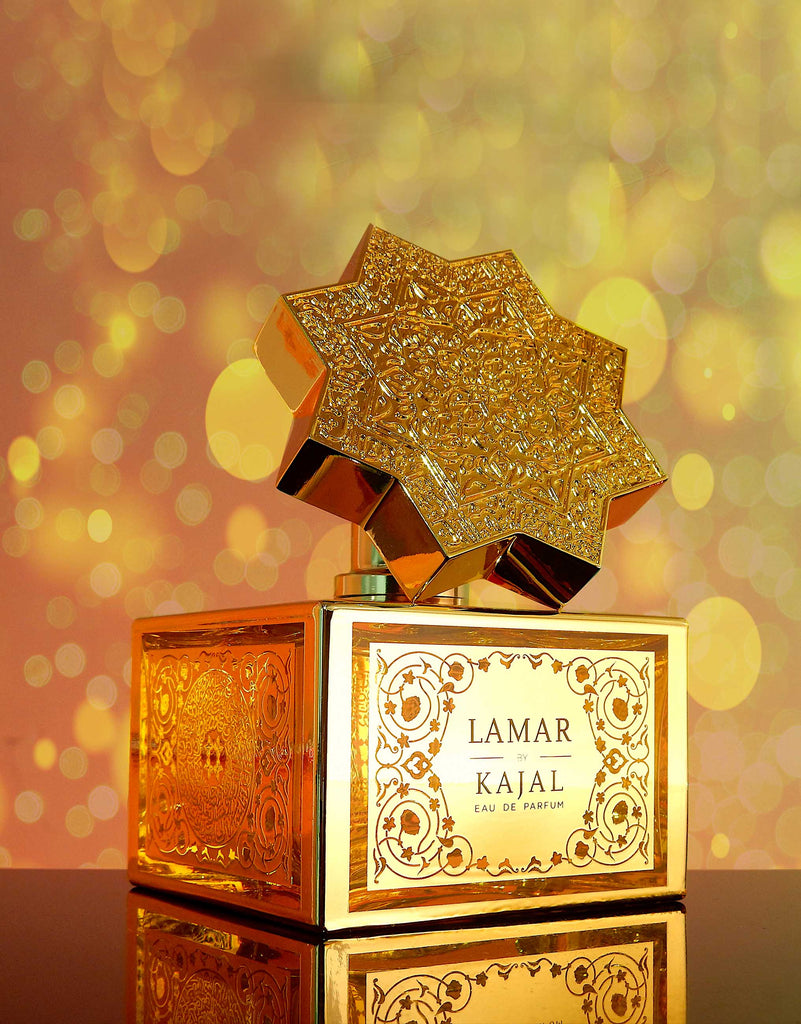 Lamar by Kajal perfume bottle with intricate gold design and star-shaped cap on reflective surface