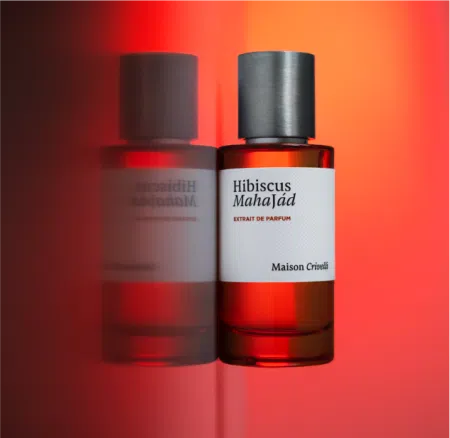 Maison Crivelli Hibiscus Mahajád Extrait de Parfum in a sleek bottle with a warm backdrop