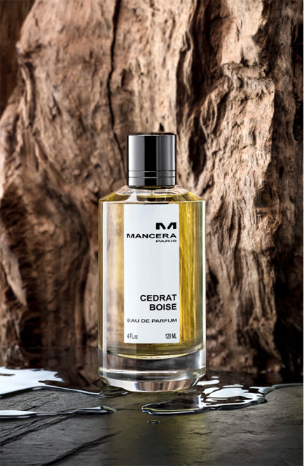 Mancera Cedrat Boise perfume bottle with golden liquid placed against textured wooden background