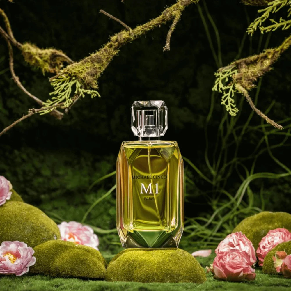 MICHAEL CINCO M1 niche perfume bottle displayed on moss with pink flowers in a forest setting