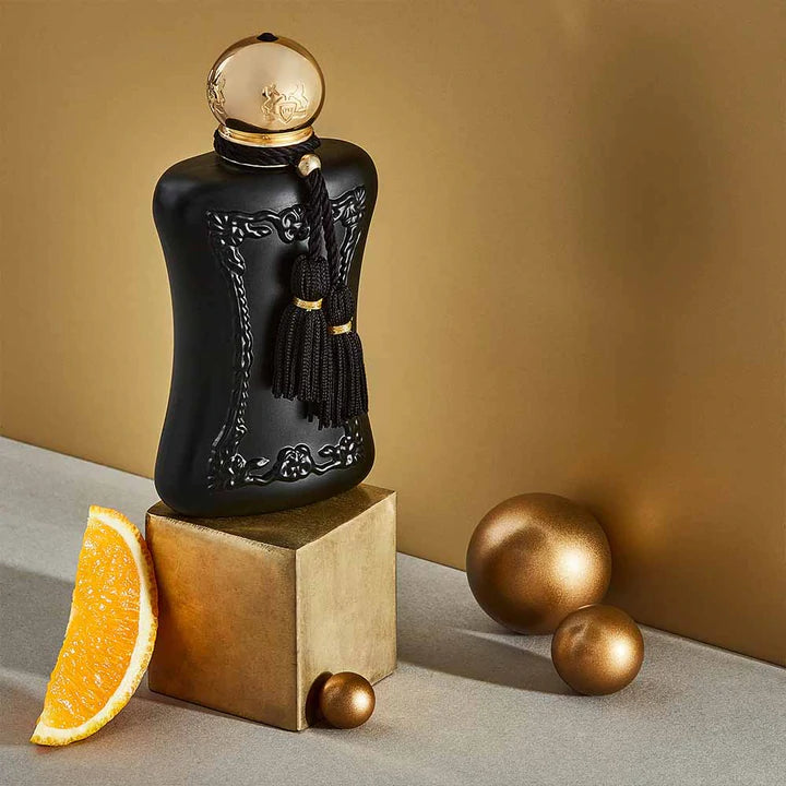 Parfums De Marly Athalia Eau de Parfum black bottle with gold cap and tassel, displayed with orange slice and gold spheres