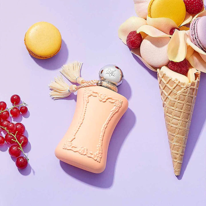 Parfums De Marly Cassili 75ml perfume bottle with decorative tassel on lavender background with macarons and berries